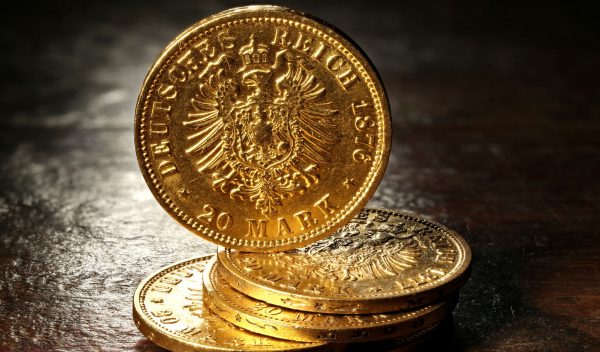 Hamburg gold coins (German Empire Goldmark) on rustic wooden bac